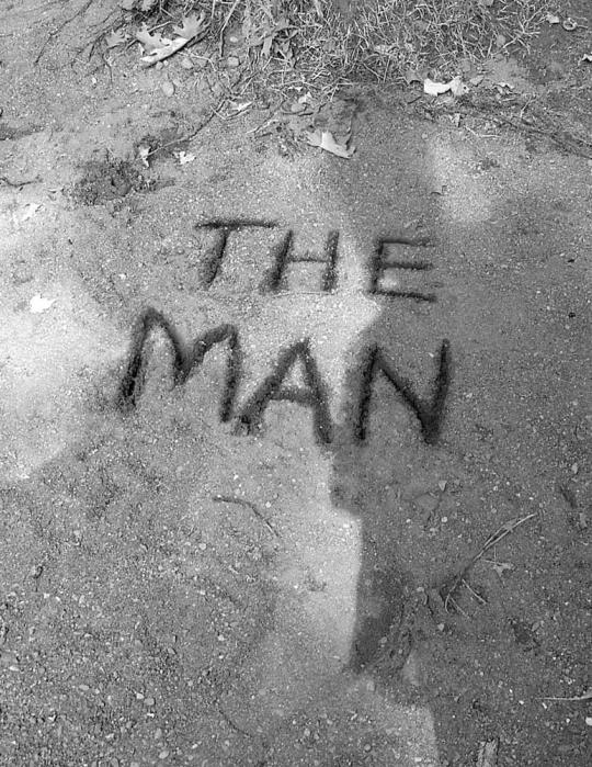 Scratched words in sand which read, "The Man"